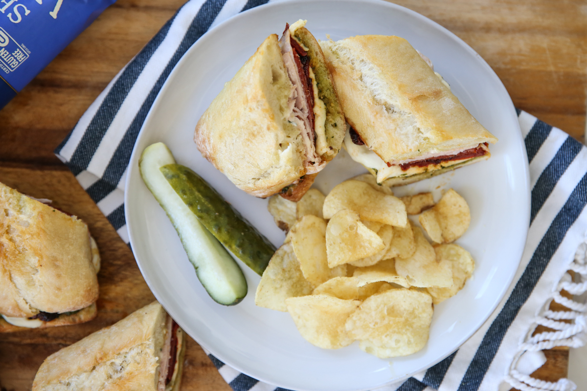 sandwich on plate with chips and pickles