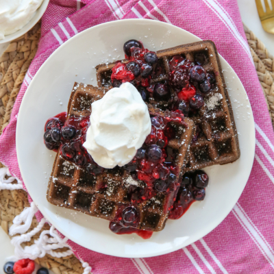 Chocolate Waffles with whipped cream and berries on a plate