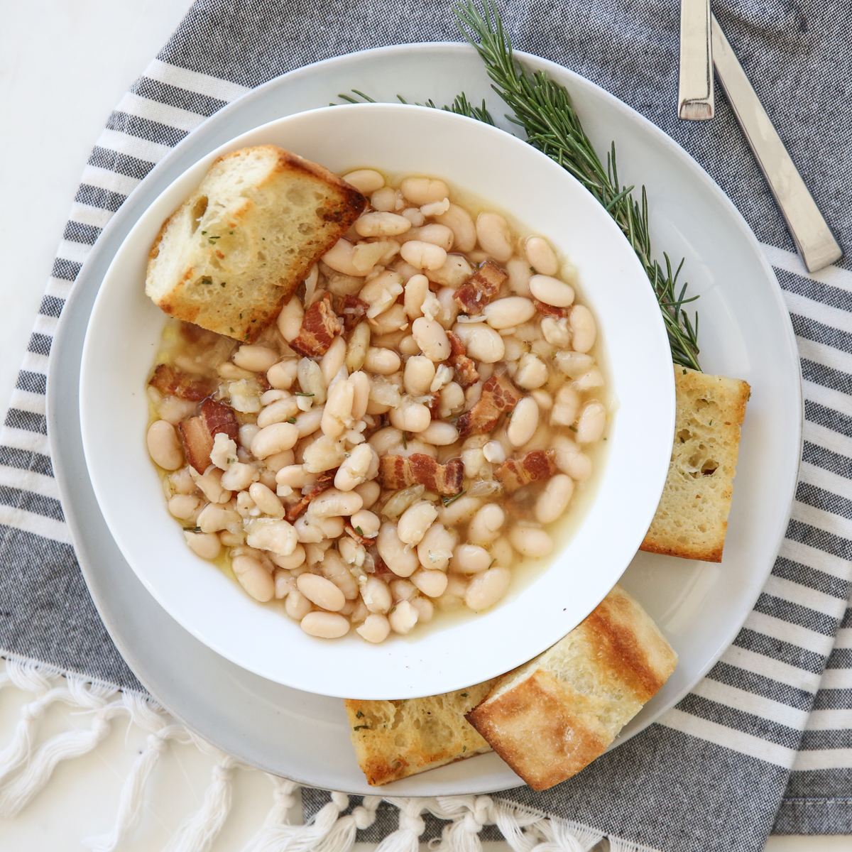 bowl of white beans with garlic bread on the side
