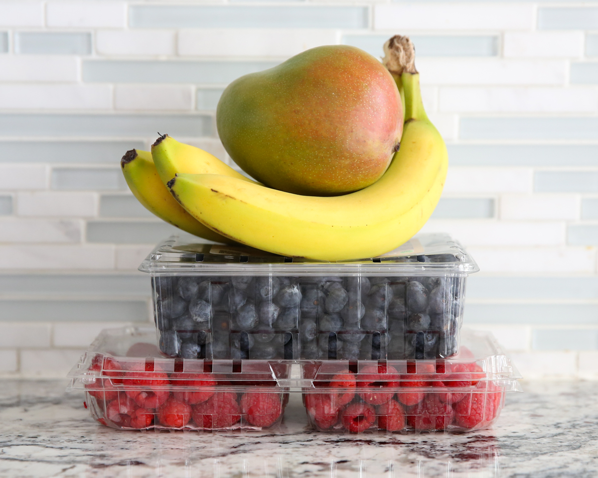 fresh fruit stacked in containers on the counter