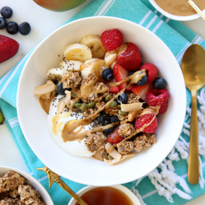 yogurt, granola, and fruit in a white bowl
