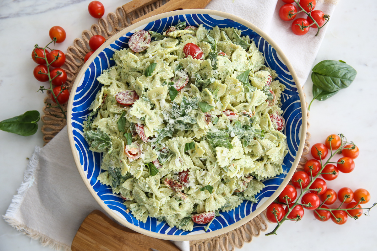 creamy pesto basil pasta in a blue and white serving bowl