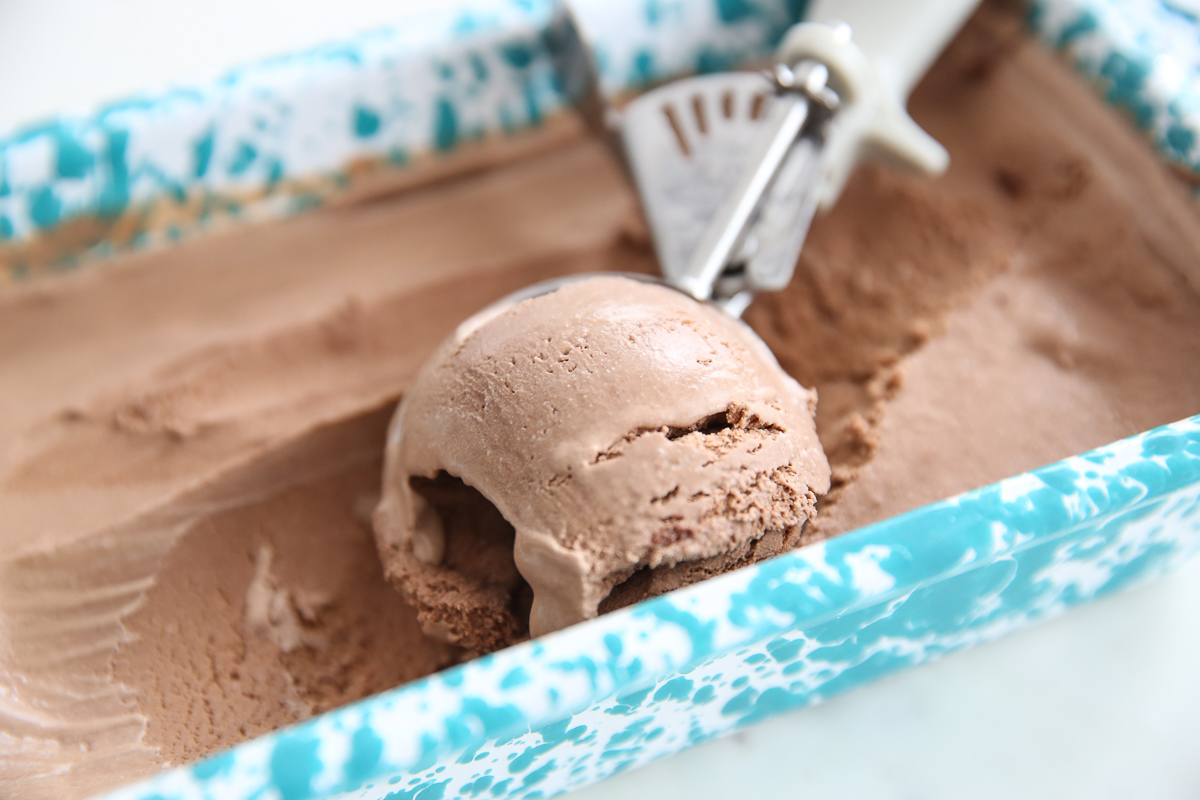 chocolate ice cream being scooped up in a speckled pan
