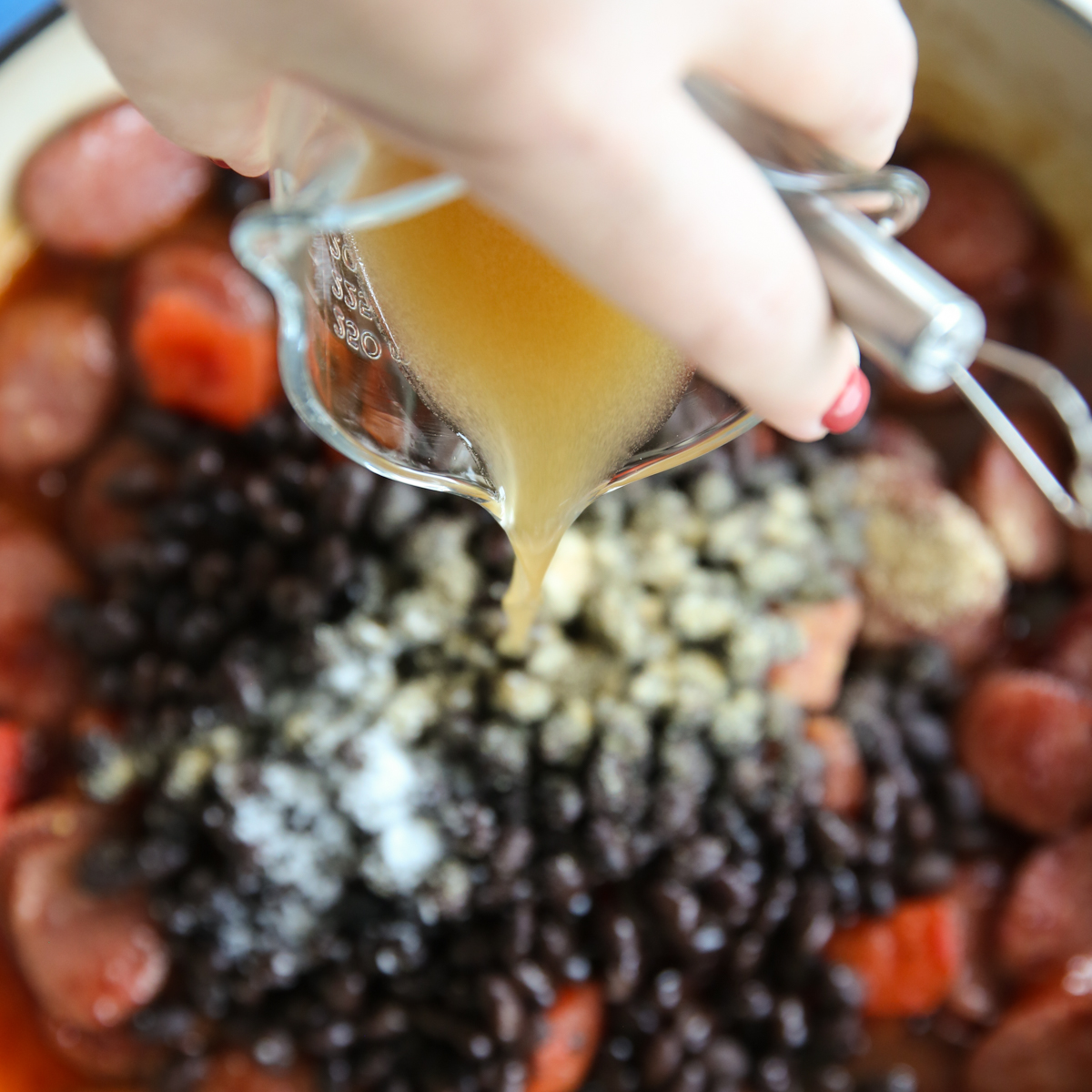 pouring beef broth into the skillet