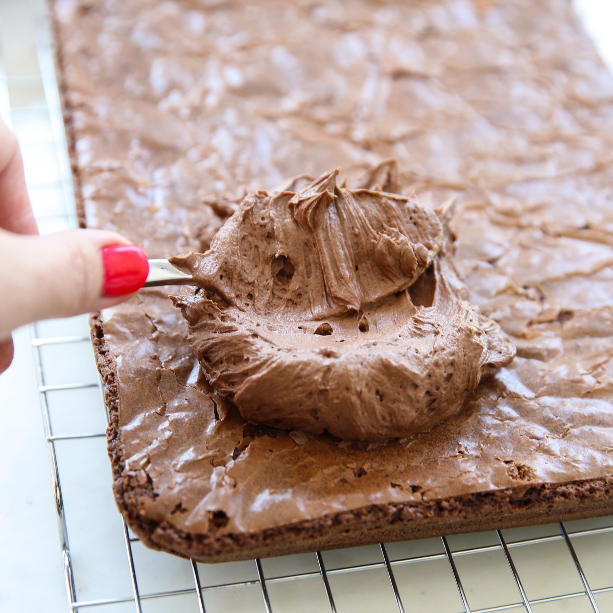 putting frosting on brownies