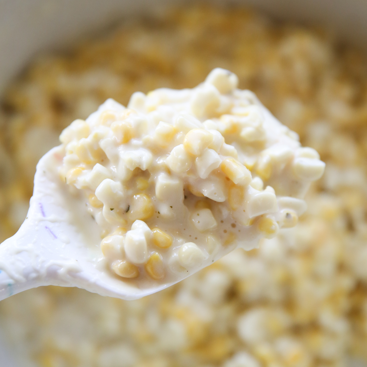 spatula holding a big spoonful of creamed corn
