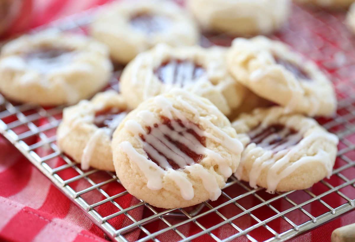 raspberry thumbprint cookies on a baking rack