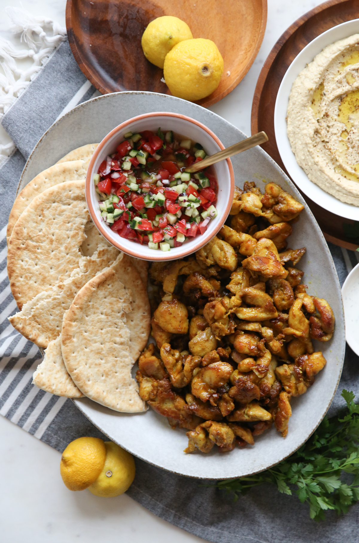 Sheet pan chicken shawarma on a plate with salad and flatbread