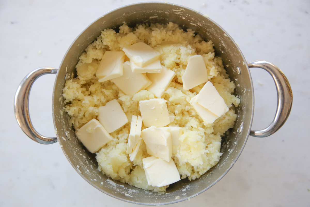 cooked potatoes and butter in a pot