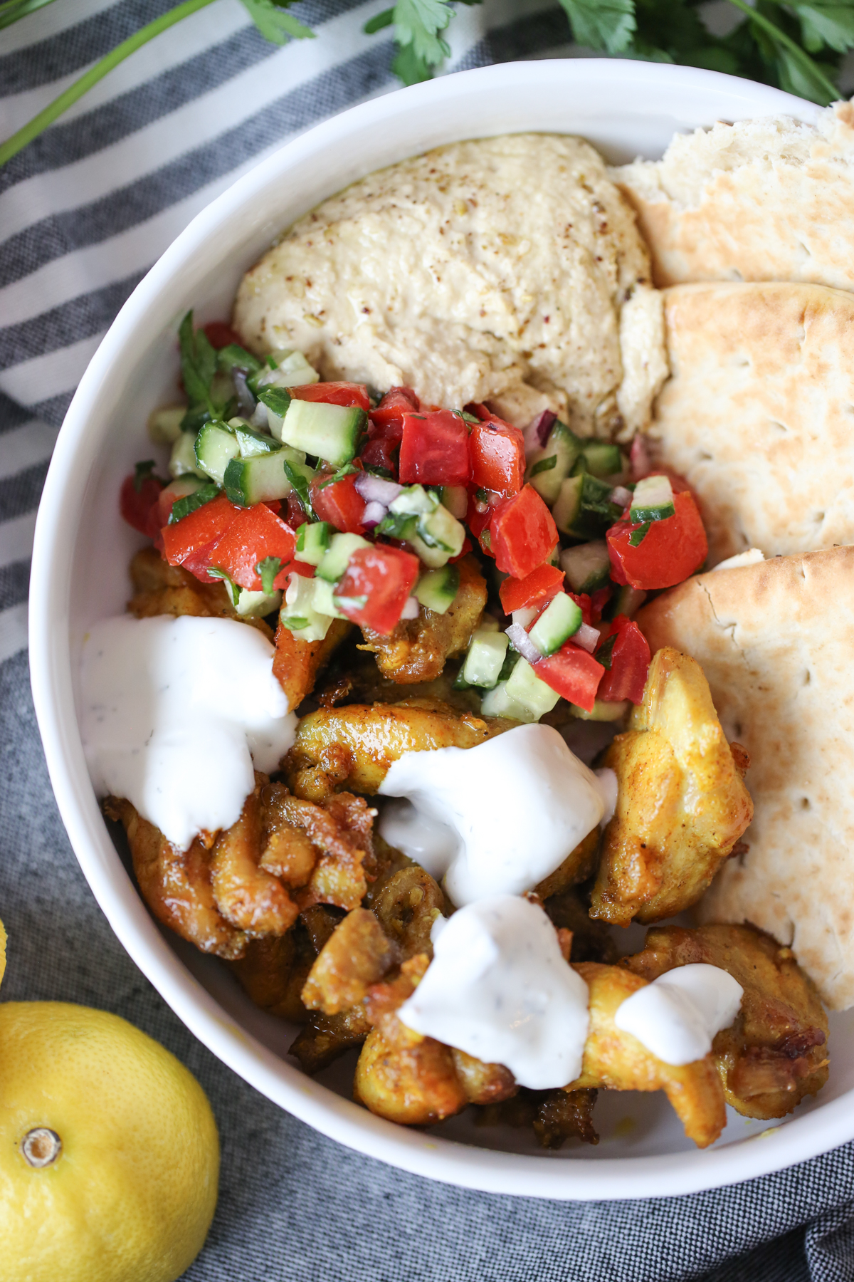 Sheet pan chicken shawarma on a plate with salad and flatbread