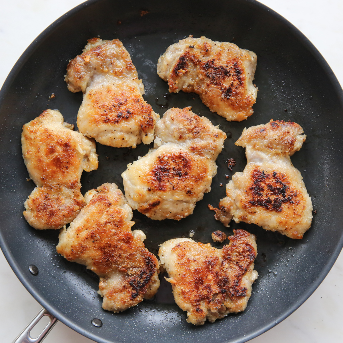 Browned Chicken thighs in a skillet