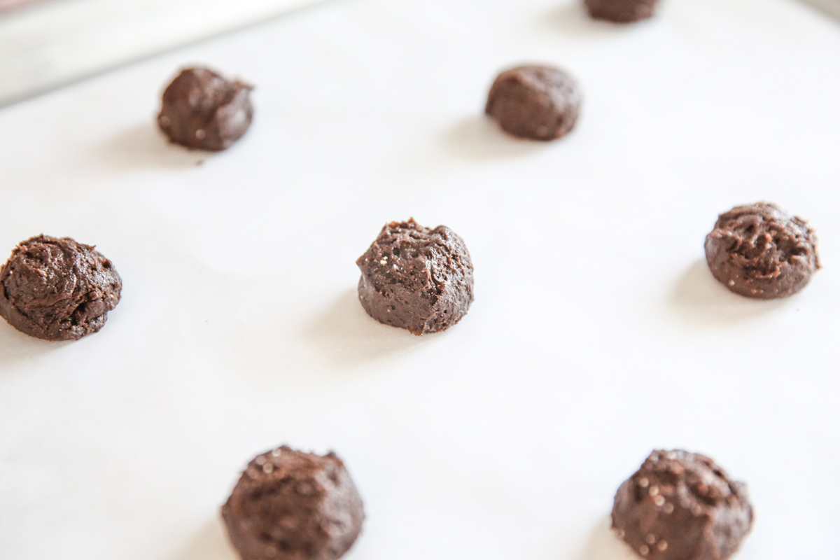 chocolate cookie dough balls on a baking sheet