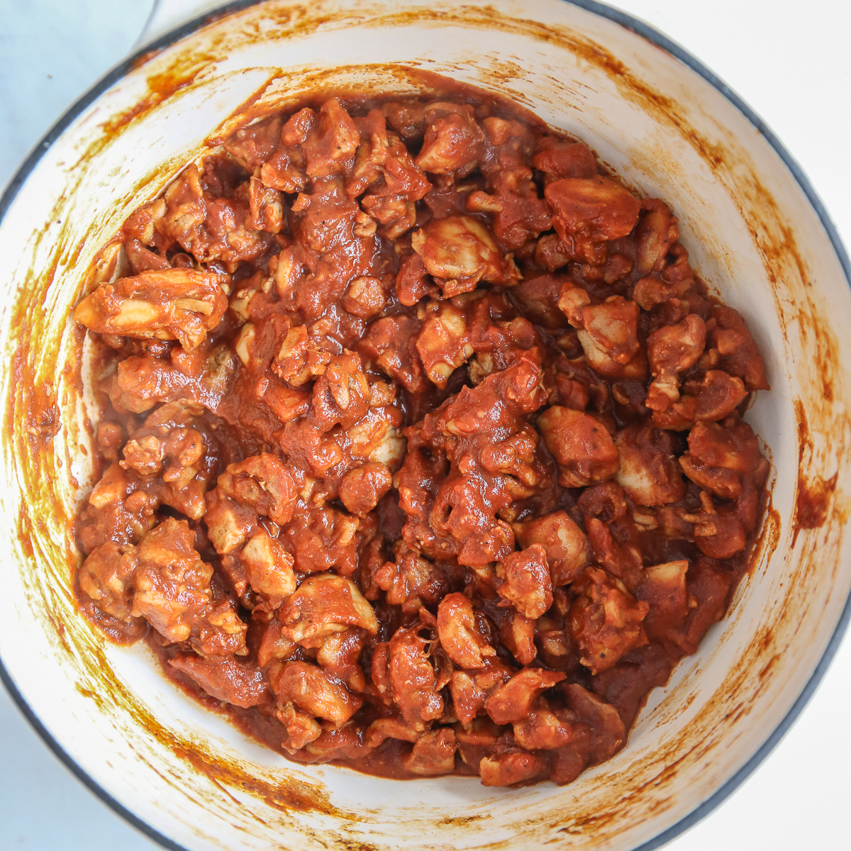 cooked butter chicken with tomato sauce and spices in a dutch oven