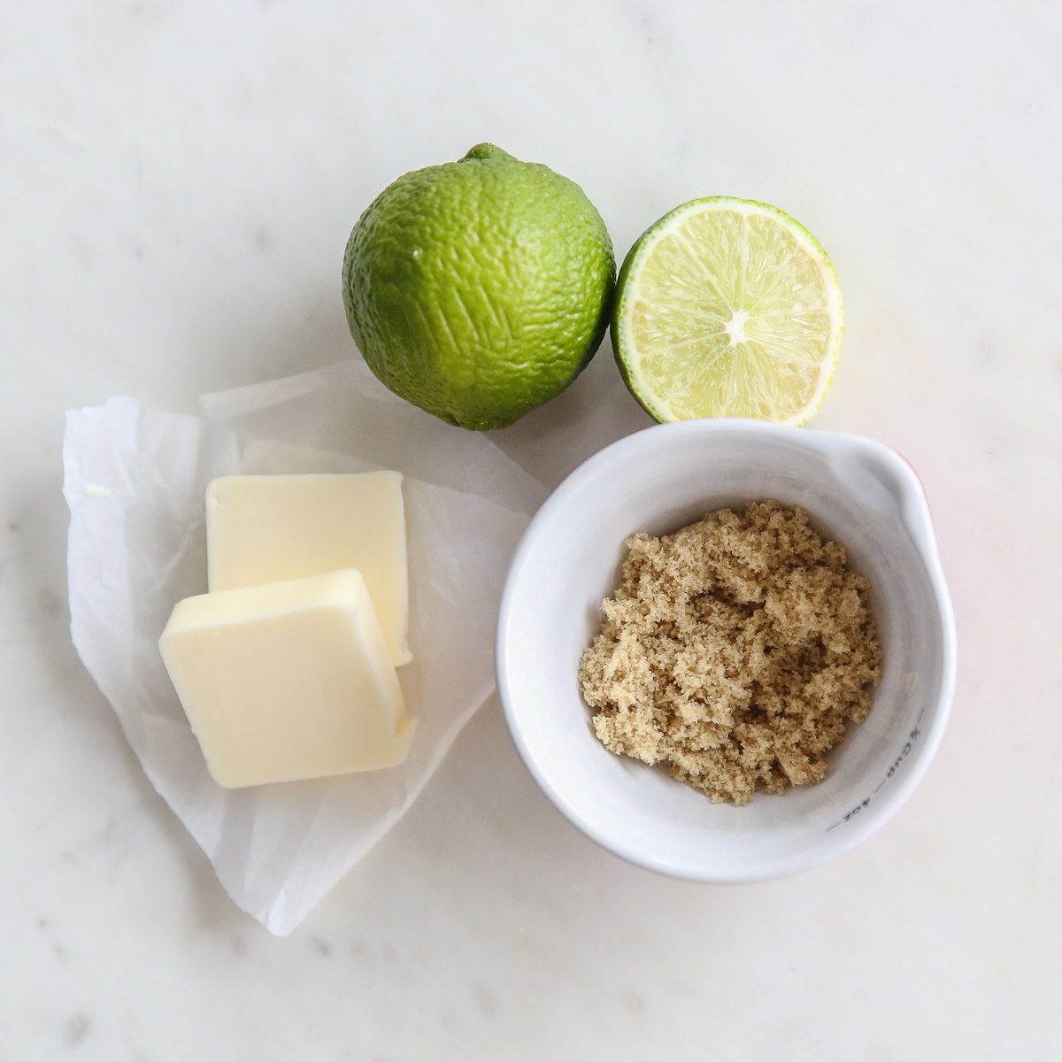 butter, lime juice, and brown sugar on a white marble table