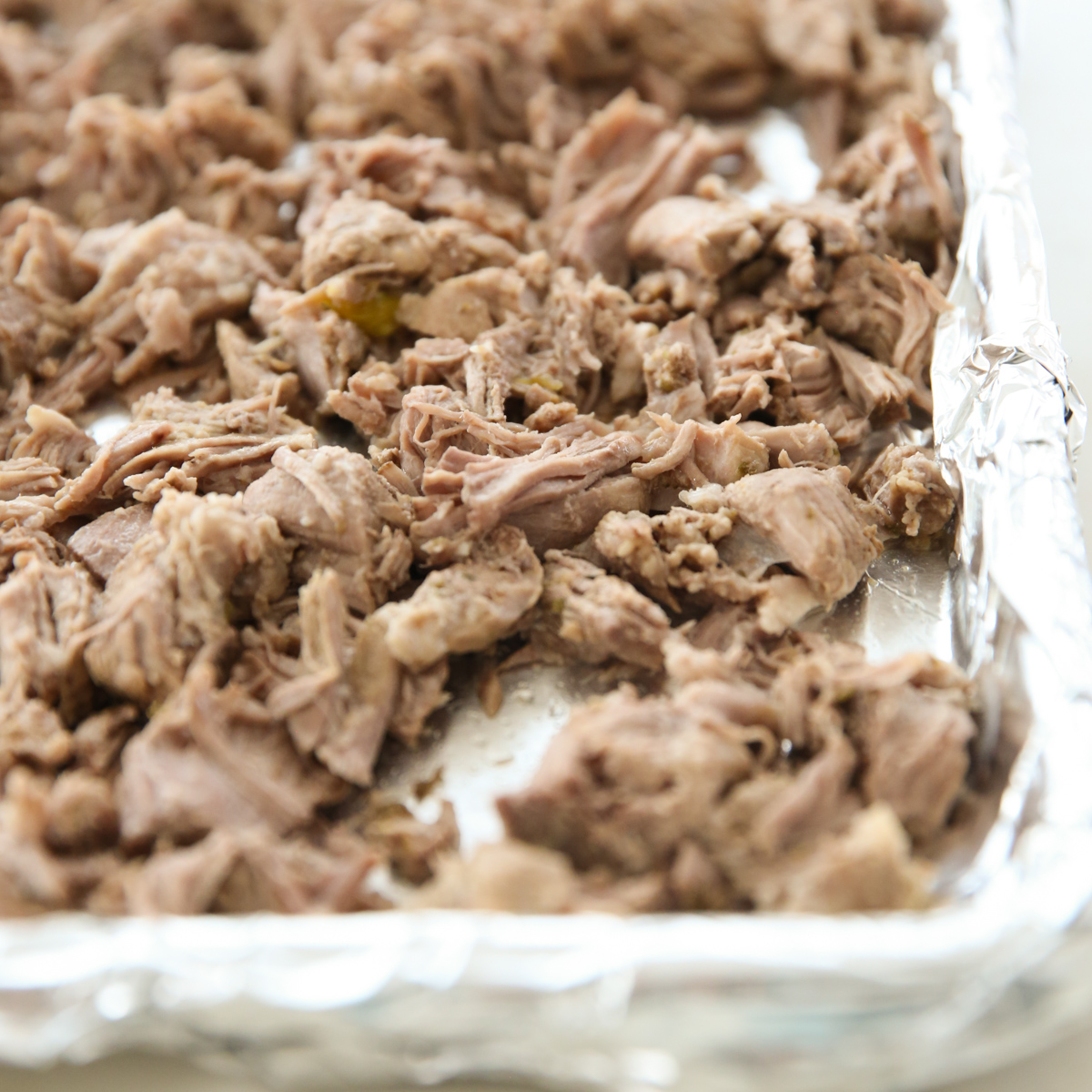a sheet pan covered in cooked pulled pork