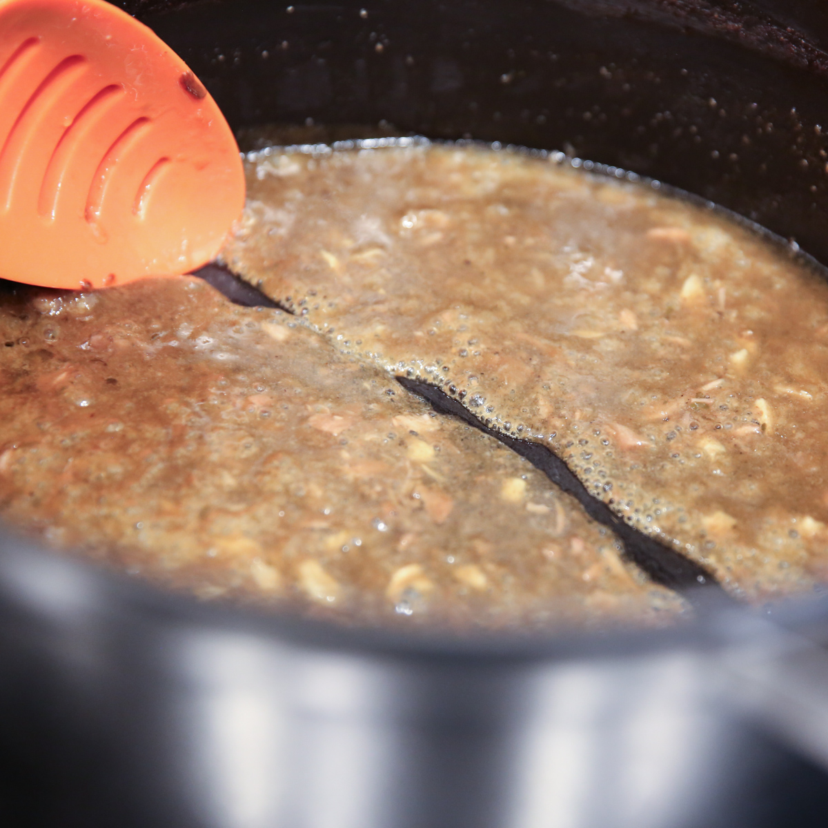 showing a simmering sauce of pork stock