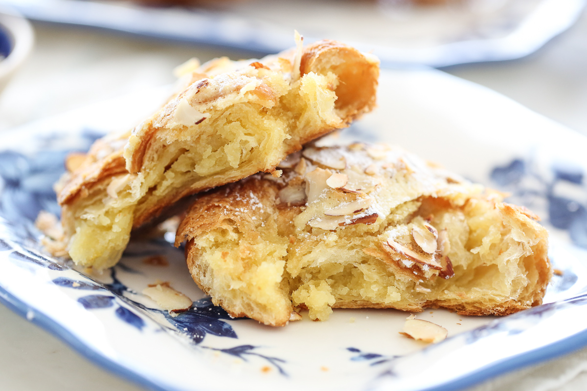Almond croissants cut in half on a blue and white plate