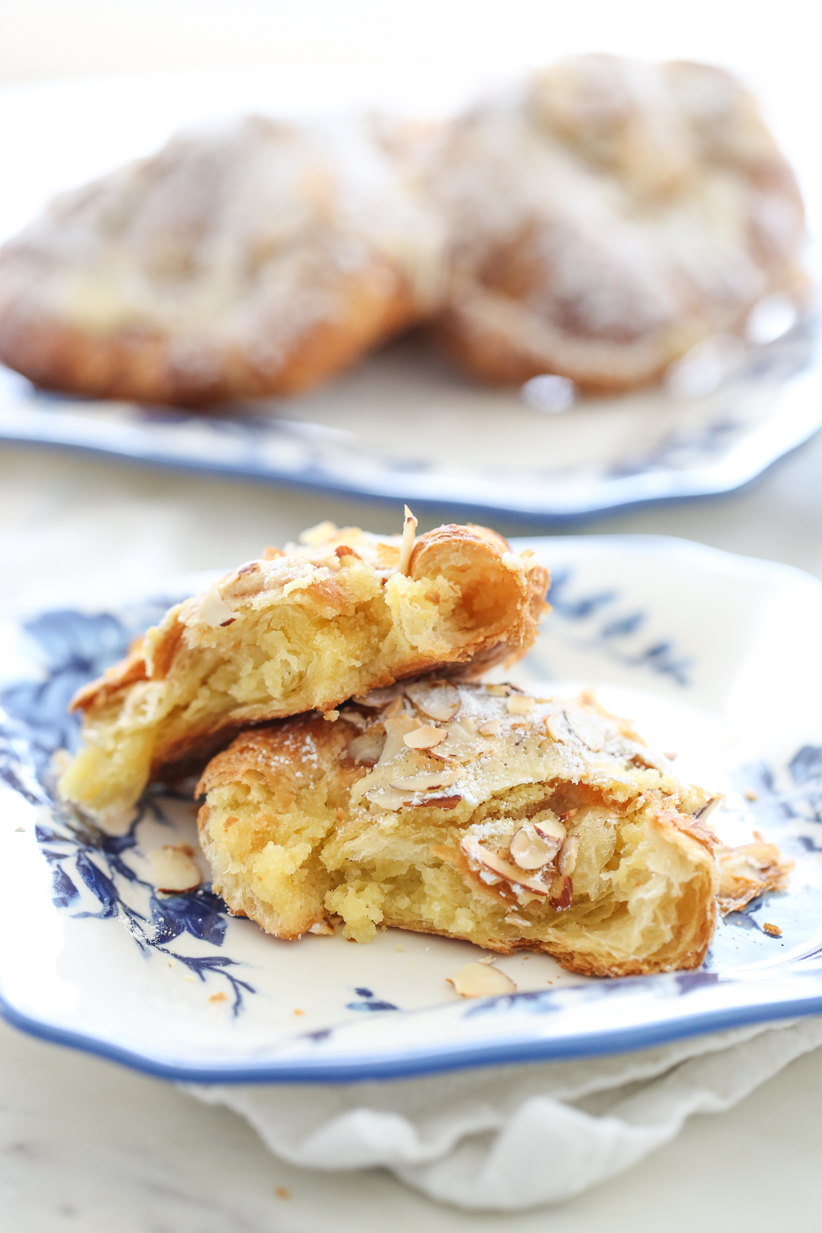 Almond croissants cut in half on a blue and white plate