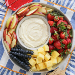 a bowl of fluffy fruit dip surrounded by fresh fruit