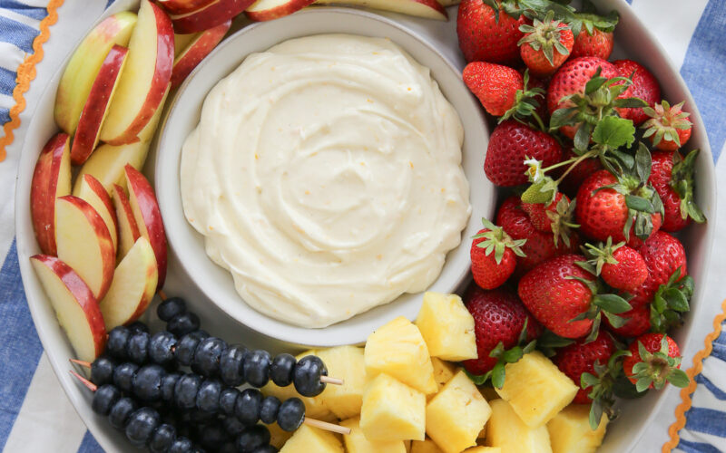 a bowl of fluffy fruit dip surrounded by fresh fruit