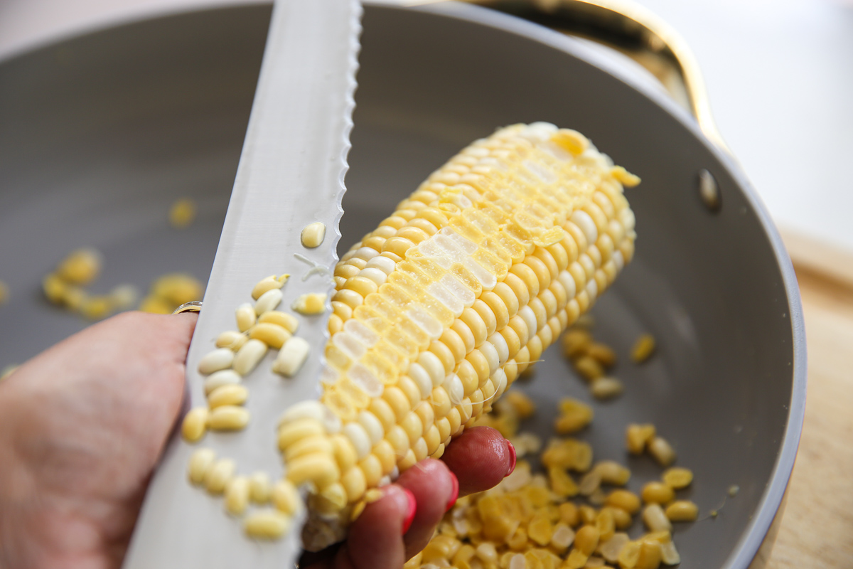 slicing tips of corn off of corn on the cob
