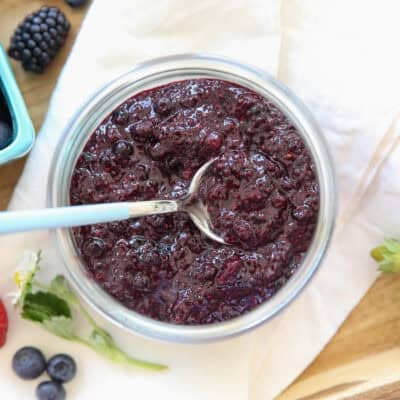blueberry chia jam in a glass jar with a spoon in it