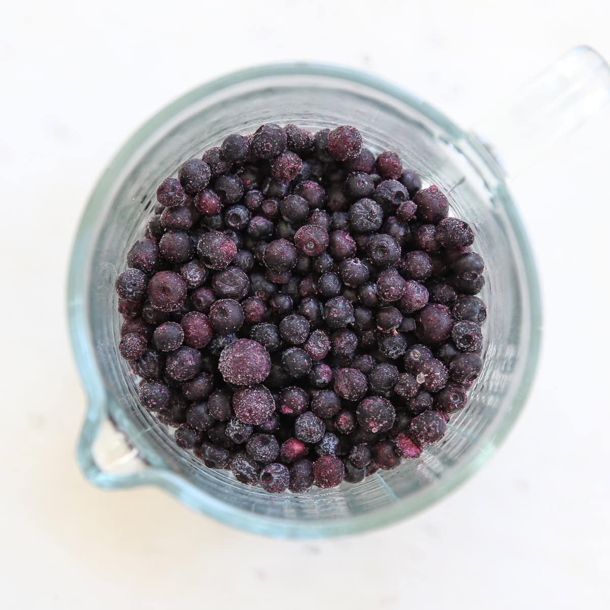 frozen blueberries in a measuring cup