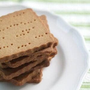 A stack of homemade graham crackers on a white plate.