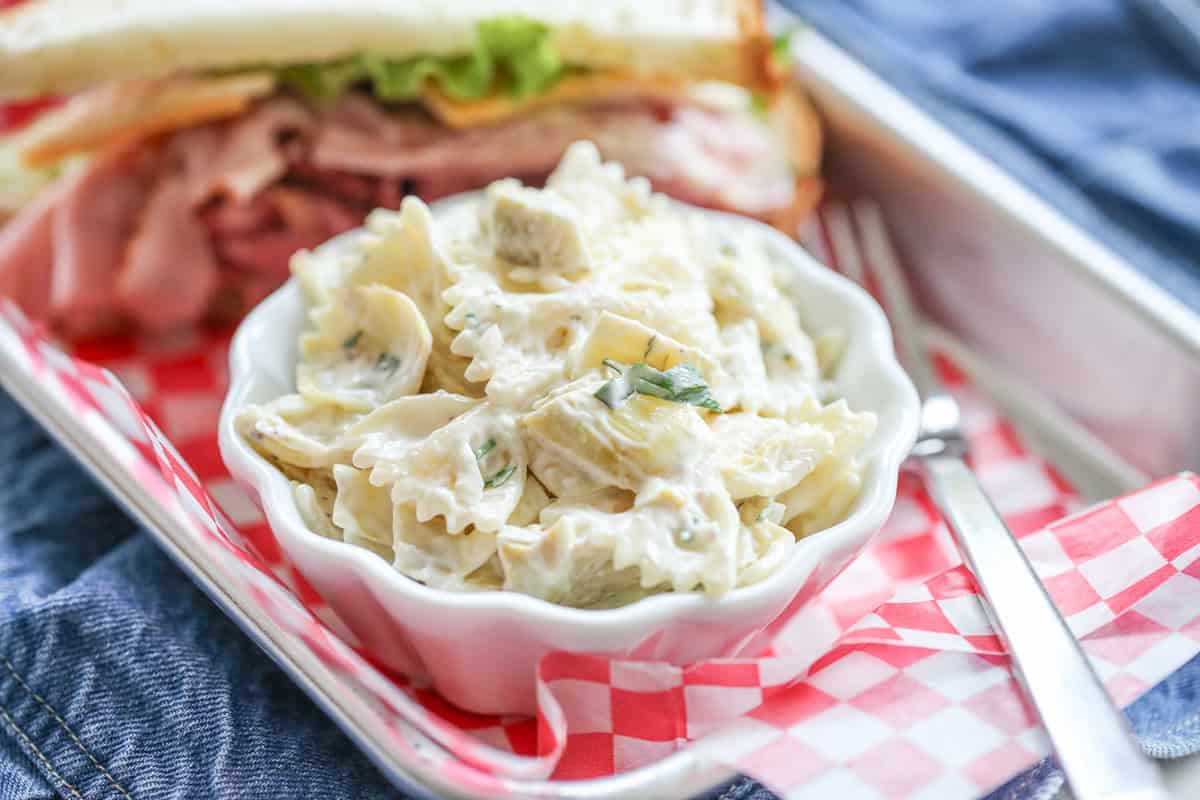 Bowl of pasta salad with creamy sauce and artichokes