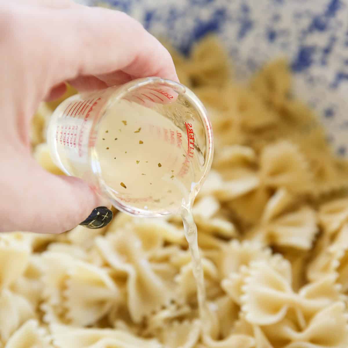 artichoke brine being poured in pasta