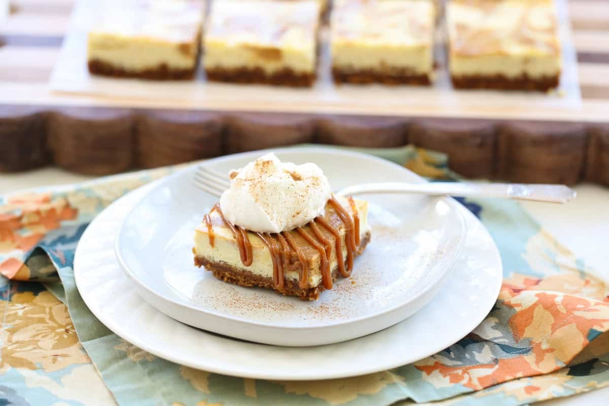 single serving cheesecake square with caramel and whipped cream