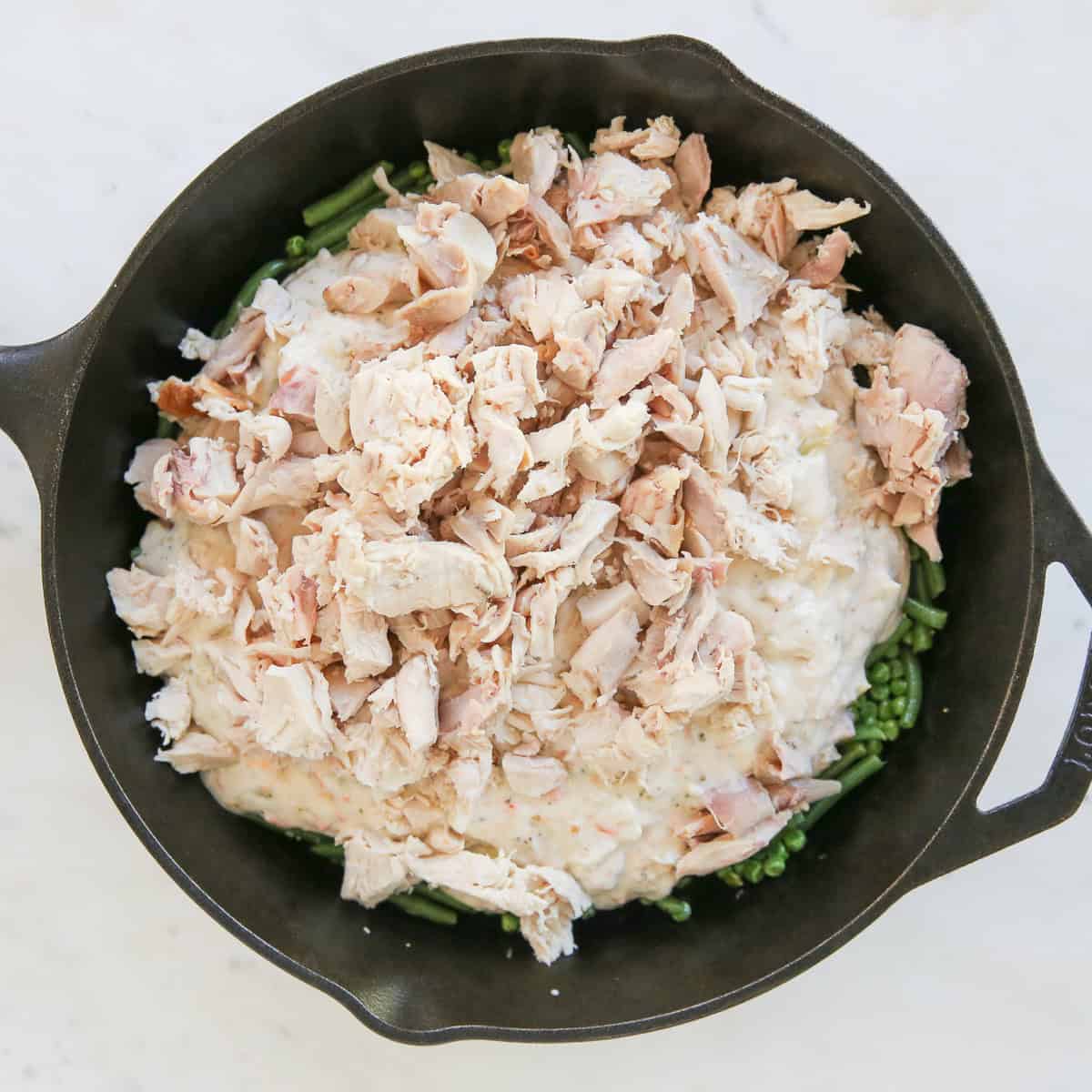 chicken pot pie ingredients in a cast iron skillet