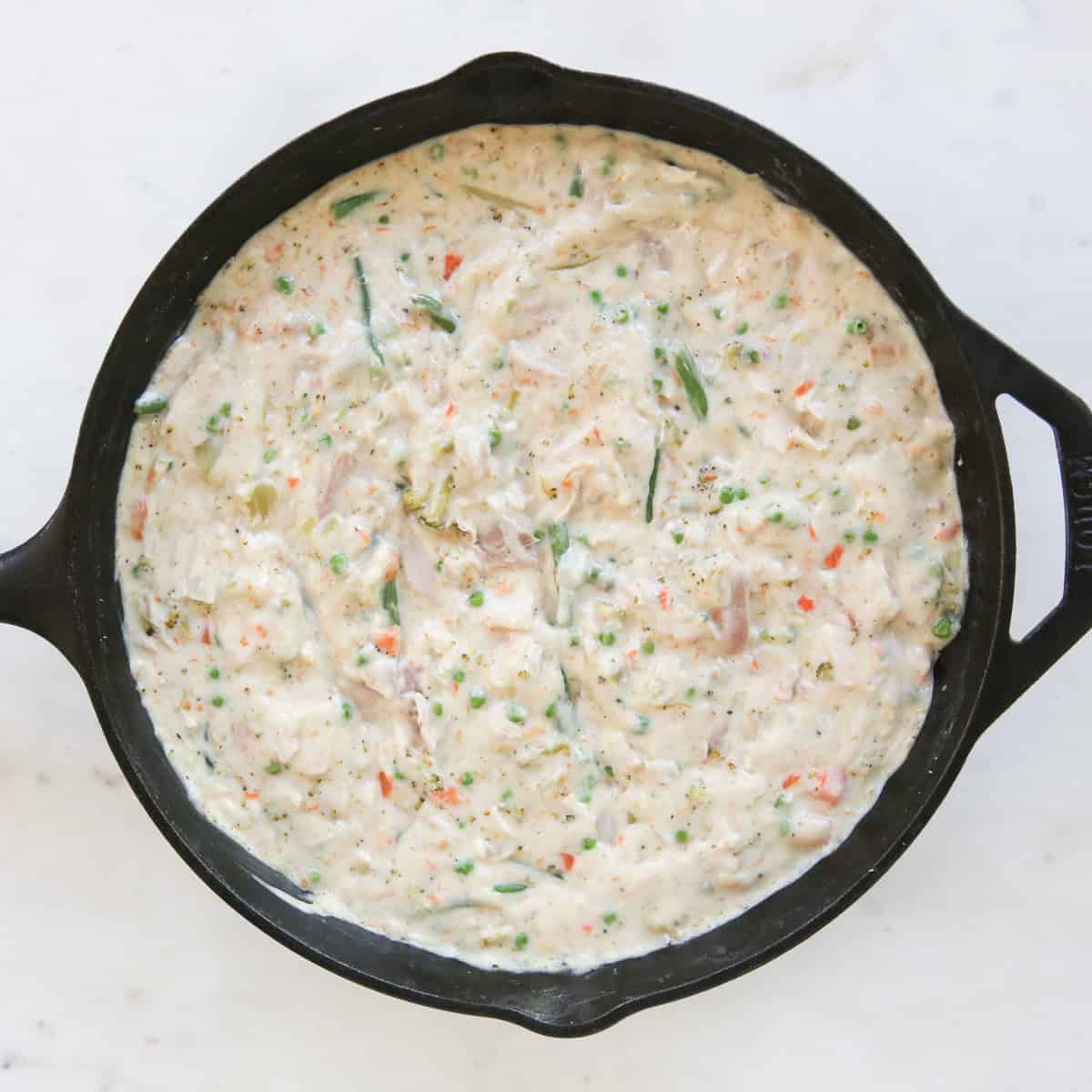 chicken pot pie ingredients in a cast iron skillet