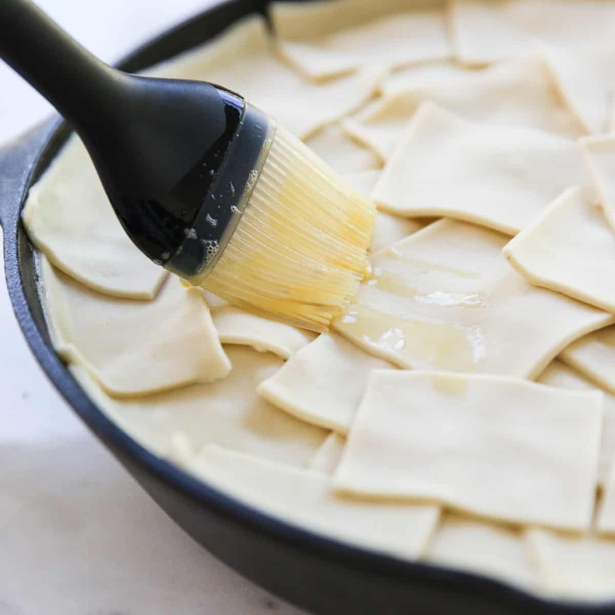 brushing egg wash over puff pastry
