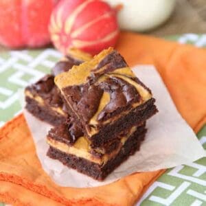 A stack of swirled pumpkin cheesecake brownies.