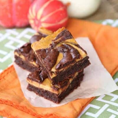 A stack of swirled pumpkin cheesecake brownies.